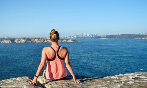 Young female hiker looks out over Sydney from the Royal National Park in NSW