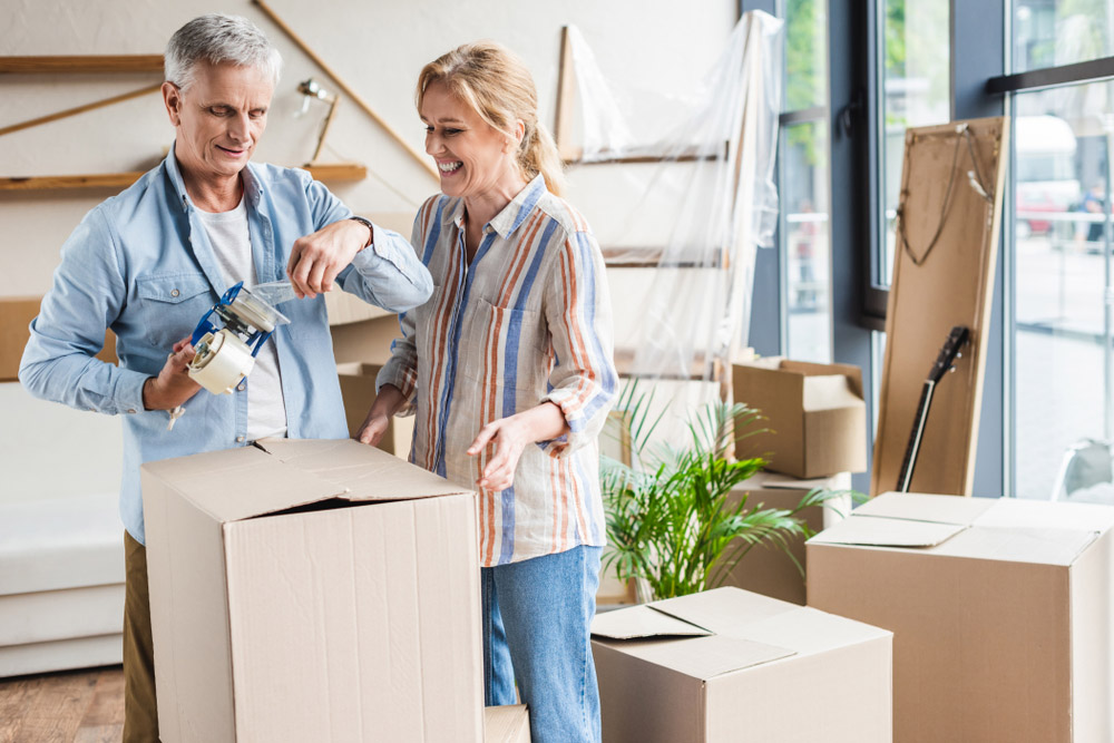 Australian couple pack up boxes before moving home.