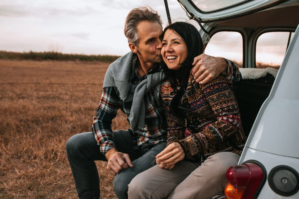 Loving Australian couple sitting in the back of the car